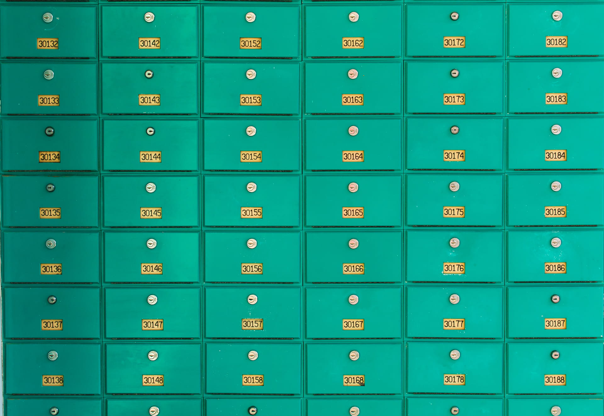 Reihe grüner Briefkästen als Symbol für MBE Center in ganz Österreich