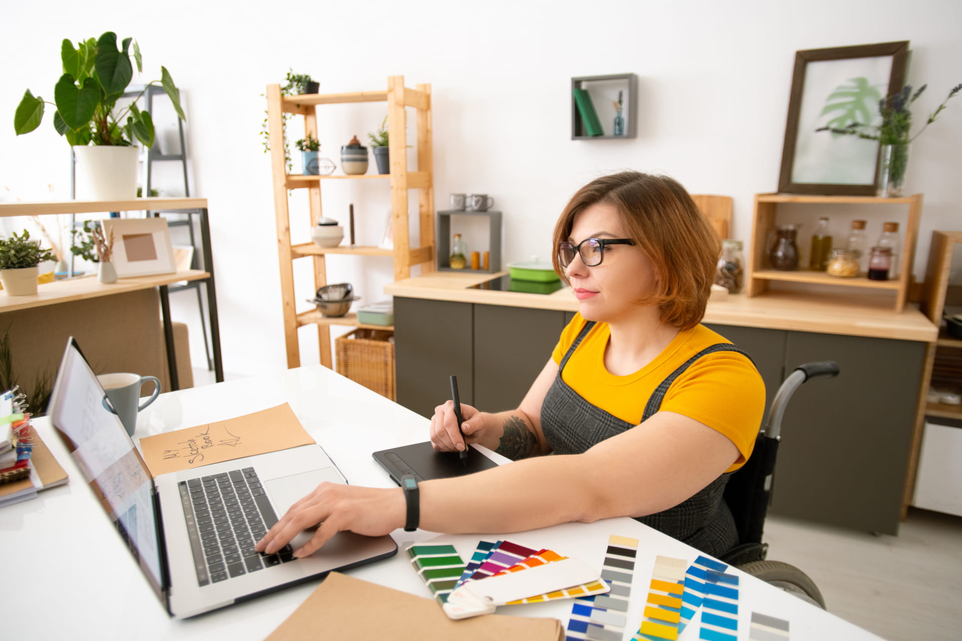 Designer stimmt digitale und gedruckte Kampagnenelemente am Tablet ab